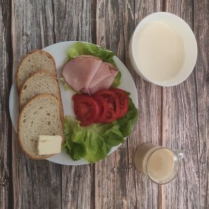 Zdjęcie przedstawia Dietę podstawową: Zacierka na mleku Chleb mieszany pszenno-żytni Masło extra Kawa zbożowa z mlekiem Szynka krucha z pieca wieprzowa, parzona Twarożek z papryką Sałata zielona Pomidor